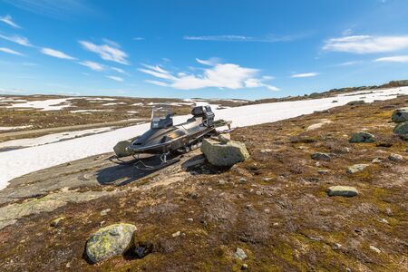 Snowmobile on a rock in the mountains in a sunny day.の写真素材