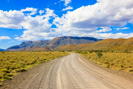 Dirt road in cloudy sky, Karoo National Park in the summer, Western Cape province of South Africa.の写真素材