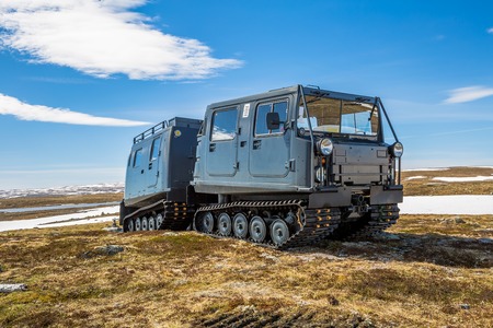 A snowcat tracked on snowy mountain landscape of the plateau Hardangervidda National Park in Norway, Europe. Right side view.の写真素材