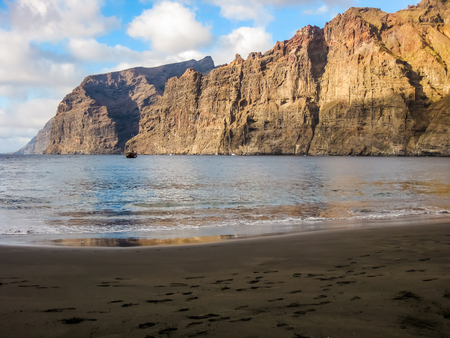 Los Gigantes beach, Tenerife, Canary Islands, Spain. Giant cliffs overlooking the Atlantic Ocean on the west coast of Tenerife with pirate sailing ship in the distance.の写真素材