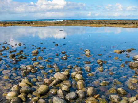 Playa Las Gallettas, Tenerife, Canary Islands. The water reflects the sky and its clouds.の写真素材