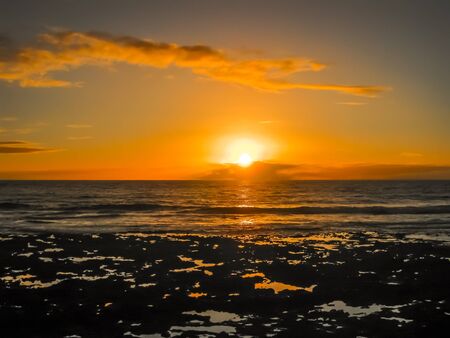 Playa de Las Americas. Colorful sunset reflecting on the water of the ocean and the rocks. Tenerife, Canary, Spain.の写真素材