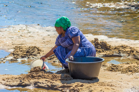 African woman collecting water from the river on the road leading to UMkhuze Game Reserve, South Africa.のeditorial素材