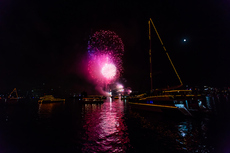 Spectacular midnight fireworks in Sydney to celebrate the new year 2015, seen from the boat in a windy and cloudy sky.  View of Opera House theater and Harbor Bridge from sea.の写真素材