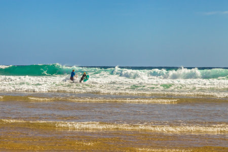 Phillip Island, Victoria, Australia - January 4, 2015: Young Australian couple practice surfing on the waves of Woolamai Beach beach windiest Phillip Island, Cape Woolamai State Faunal Reserveのeditorial素材