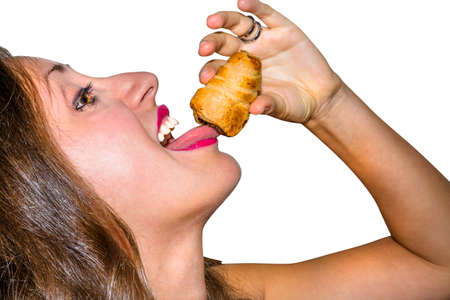 Girl enjoying a delicious pastry filled with chocolate in white background, isolated.の写真素材