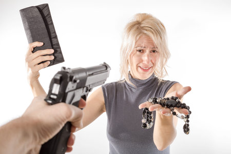 Terrified woman during aggression for money and jewelry by a man holding a gun. Pure white...