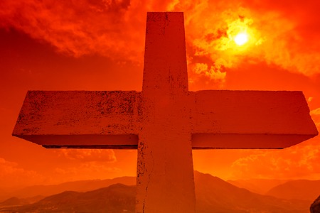 Dramatic sky scenery at sunset with a closeup of the Christian cross. Symbol of hope, salvation and the Jubilee of Mercy, Rome Holy Year 2015.の写真素材