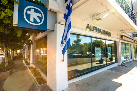 Olimpia town, Peloponnese, Greece - August 19, 2015:  Greek bank window with ATM and flag of Greece of the local Alpha Bankのeditorial素材