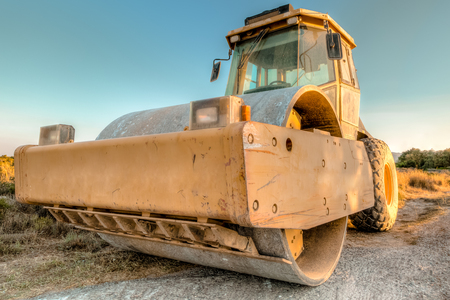 Closeup of steamroller in a suggestive construction site at dawn. Concept of work in progress.の写真素材