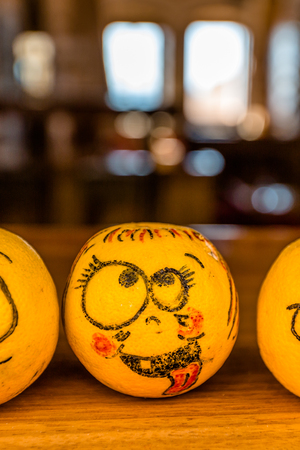 One funny happy face painted orange with bokeh defocused blur background in autumn halloween theme.の写真素材