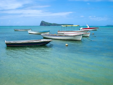 Fishing boats in Malheureux a small fishing village with a beautiful clear blue waters. Located at the northernmost tip of the country near Grand Baie and Pereybere. In the background, Coin de Mire.の写真素材