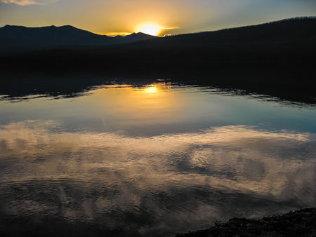 Lake in Glacier National Park at sunset reflected, Montana, United States.