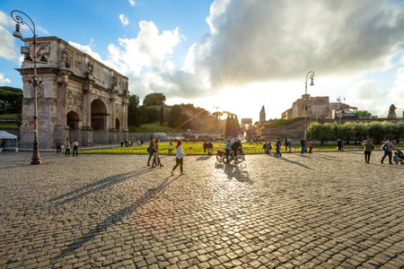 Rome, Italy - May 12, 2016: People and tourists walking in front of the Arch of Constantine spectacular at sunset, located between the Colosseum and the Arch of Titus on the Roman road.のeditorial素材