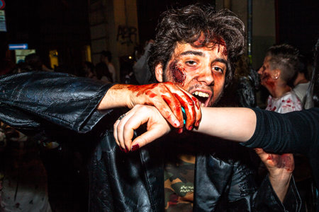 Bologna, Italy - May 21, 2016: Bologna zombie apocalypse walk: closeup of a vampire biting the arm of a victim.のeditorial素材