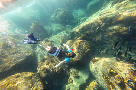 Man apnea swims in deep waters of the popular Similan Islands in Thailand, Andaman Sea.