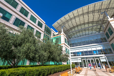Cupertino, CA, USA - August 15, 2016: people walk in front of the Apple world headquarters at One Infinite Loop. Apple is a multinational corporation that produces technology devise.のeditorial素材