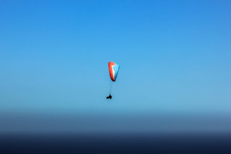 Paragliding over Table Mountain National Park in Cape Town, Western Cape, South Africa in the blue...