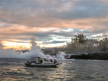 Big Island, Hawaii, United States - August 7, 2010: popular sunrise lava boat tour Hawaii. Tourists on a speedboat, observed during a tour, the lava of Kilauea Volcano as it enters the Pacific Ocean.のeditorial素材