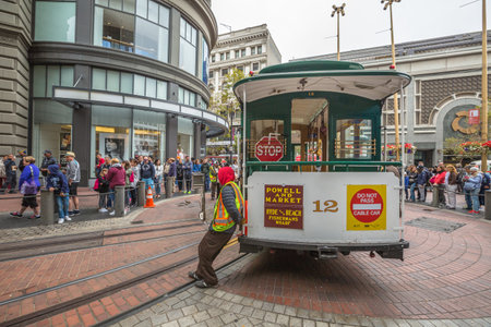 San Francisco, CA, USA - August 15, 2016: Cable car operators push the turntable around the reverse direction in Powell and Market St Turntable or terminus while crowds of tourists waiting to go up.のeditorial素材