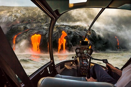 Helicopter cockpit flies in Kilauea Volcano, Big Island, Hawaii, United States by sunset, with pilot arm and control board inside the cabin.の写真素材