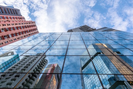 Sky Blue Glass High-rise Facade. Panoramic wide angle view and perspective to steel light background of glass high rise buildings. Causeway Bay, Hong Kong Island.の写真素材