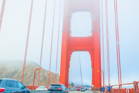 San Francisco, California, United States - August 17, 2016: point of view of cars crossing the Golden Gate Bridge from the Presidio Pacific point to the north. People are jogging along the bridge.のeditorial素材