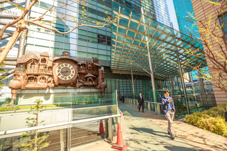 Tokyo, Japan - April 20, 2017: Japanese white-collar workers walking in Shiodome area. Business people commuter in front of Ghibli clock at Nittele Tower (Nippon Television headquarters) in Shinbashi.のeditorial素材