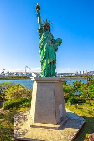 Urban landscape of Statue of Liberty and Rainbow Bridge, icons of Odaiba Island in Tokyo, Japan. Replica of famous Statue of Liberty of New York. Tokyo cityscape on background. Vertical shot.の写真素材