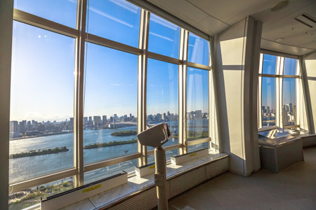 Tokyo, Japan - April 19, 2017: tourist binocular at free viewing of Rainbow Bridge and Tokyo Skyline from Fuji Television Observatory in Odaiba island. Observatory deck interior.のeditorial素材
