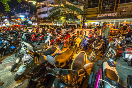 Patong, Phuket, Thailand - January 1, 2016:many scooters parked on sidewalk and street, crowd of tourists, local people with bikes and congested traffic during new year in Patong, famous for nightlifeのeditorial素材