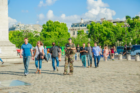 PARIS, FRANCE - JULY 2, 2017: soldier of national Armed Forces of France, keeping security after recent terrorist attacks in Paris. Arc de Triomphe at the center of Place Charles de Gaulle.のeditorial素材
