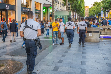 PARIS, FRANCE - JULY 2, 2017: policemen patrolling the Avenue des Champs Elysees from the Place Charles de Gaulle, Arc de Triomphe. Keeping security after recent terrorist attacks in Paris.のeditorial素材