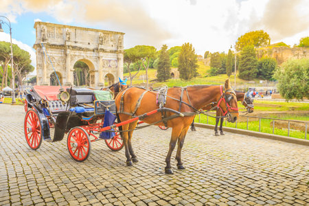 Rome, Italy - May 12, 2016: Typical horse-drawn carriage with tourists in front of Colosseo, Colosseum, with Arco di Costantino, one of the symbols of Italy.のeditorial素材