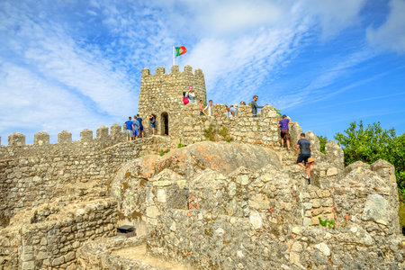 Sintra, Portugal - August 7, 2017: old wall and defensive tower of Castle of the Moors and Sintra valley, Lisbon District. People walk over defensive walls in one of Sintras most popular attractionsのeditorial素材