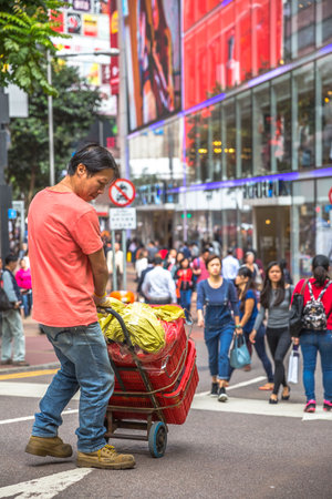 Hong Kong, China - December 6, 2016: asian worker carring his goods on the street market Jardines Crescent, Causeway Bay, shopping district, full of life and world famous brand shops.のeditorial素材