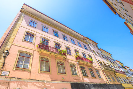 Coimbra, Portugal - August 14, 2017: windows architecture of historic buildings in Rua Ferreira Borges in center of Lower Coimbra, the medieval part of Portuguese city. Prospective view. Sunny dayのeditorial素材