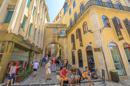 Coimbra, Portugal - August 14, 2017: people walk through Tower and Arch of Almedina, the iconic Archway of Almedina, fortification of Manuelino period in historic medieval Coimbra, Central Portugal.のeditorial素材