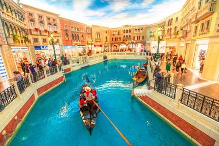 Macau, China - December 9, 2016: gondolier with tourists during a ride in an authentic gondola down Grand Canals at the Venetian Luxury Hotel and Casino. Inside shopping mall in Cotai Strip.のeditorial素材