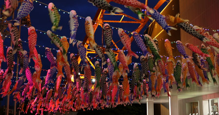 Tokyo, Japan - April 23, 2017: Koinobori a carp-shaped wind socks traditionally flown in Japan to celebrate Childrens Day. Tokyo Tower by night on background. Horizontal shot.のeditorial素材