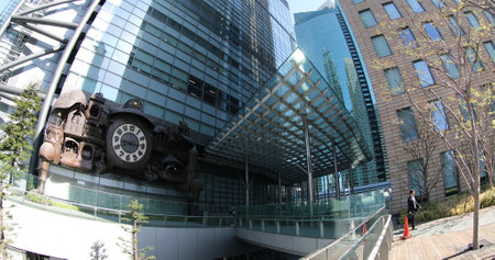 Tokyo, Japan - April 20, 2017: Nippon Television HQ with Japanese white-collar business workers walking in Shiodome area. Ghibli clock at Nittele Tower in Shinbashi. fisheye effect.のeditorial素材