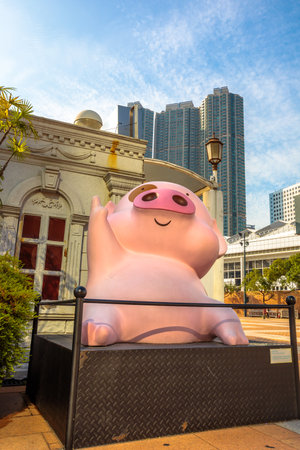 Hong Kong, China - December 5, 2016: McDull, statues of famous characters, in Hong Kong Avenue of Comic Stars, Kowloon Park. Urban skyline with cloud background of Tsim Sha Tsui District.のeditorial素材