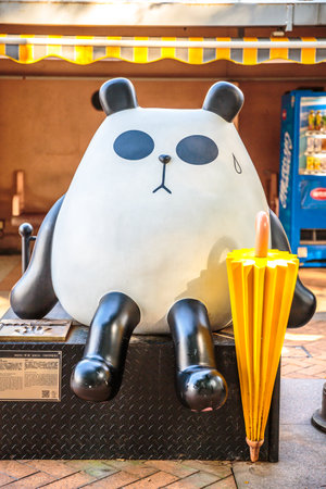 Hong Kong, China - December 5, 2016: close up of Statue of On On and Guy Guy with umbrella, sitting on a branch with a background of wall and a coke shop machine. Avenue of Comic Stars in Kowloon Parkのeditorial素材
