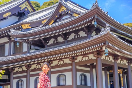 Kamakura, Japan - April 23, 2017: smiling young woman wearing japanese kimono at Kannon-do or Main hall of Hase-dera Temple in Kamakura. Japanese culture and lifestyle. Spring season.のeditorial素材