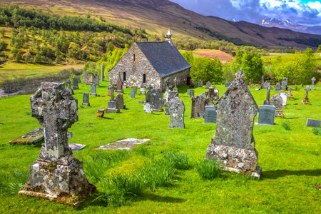 Glen Spean, Scotland, United Kingdom - May 24, 2015: Cille Choirill cemetery with ancient graves in a grass field and its Roman Catholic church in Lochaber area in the west Scottish Highlands.のeditorial素材