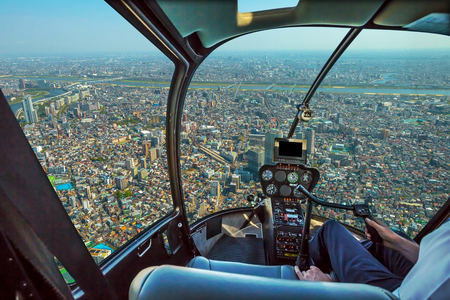 Helicopter cockpit inside the cabin flying on Tokyo cityscape. Sumida District, Japan. Sunny day.の写真素材