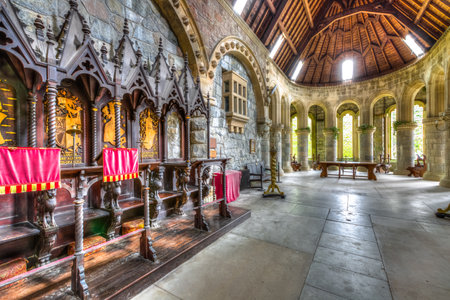 Argyll, Scottish highlands, United Kingdom - June 1, 2015: wooden chairs in the chancel hall of Saint Conans Kirk gothic church. Marble colonnade and main altar on background.のeditorial素材