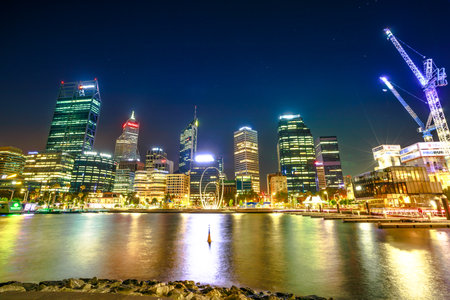 Perth, Australia - Jan 5, 2018: Esplanade with modern skyscrapers and construction cranes reflecting on the Swan River from Elizabeth Quay marina, Western Australia.Urban night scene. Popular landmarkのeditorial素材