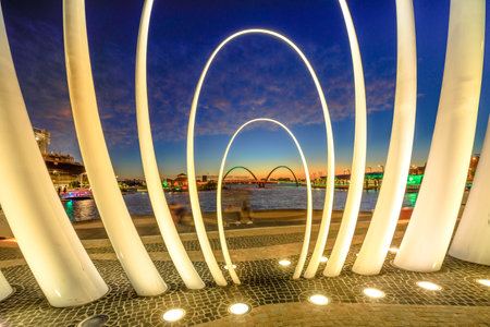Perth, Australia - Jan 6, 2018: details of iconic Spanda Sculpture illuminated at night in Elizabeth Quay Marina. Elizabeth Quay Pedestrian Bridge on Swan River on background.のeditorial素材