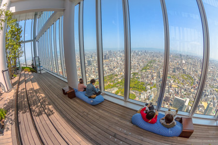 Osaka, Japan - April 30, 2017: tourists relaxing on the sofas inside the viewing platform of Osakas Abeno Harukas, the tallest skyscraper in Japan, enjoying Osaka skyline.のeditorial素材